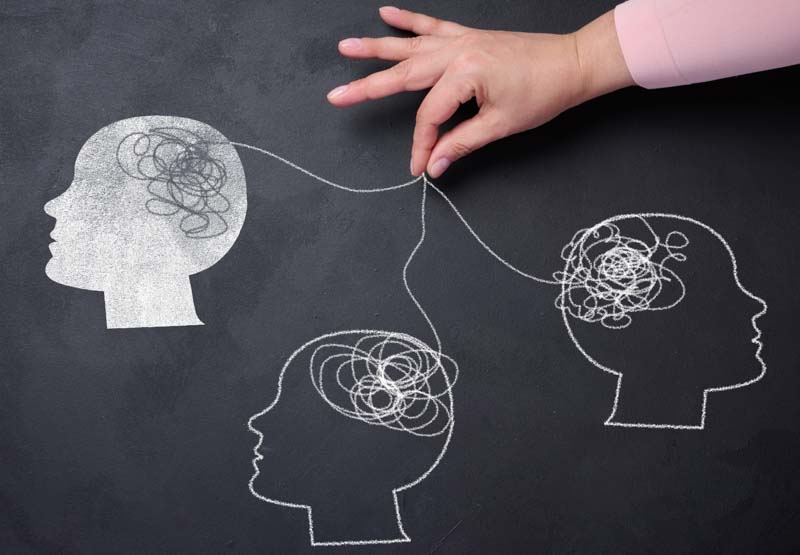 Silhouettes of human heads and a hand with threads, representing the concept of mass manipulation and influence on opinions